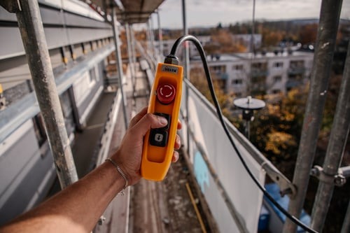 Bedienung des Bauaufzugs am Gerüst während einer Balkonsanierung