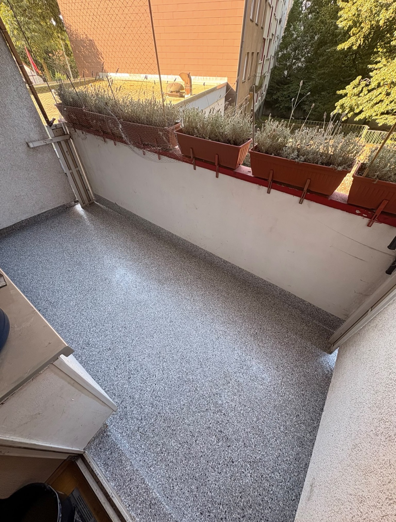 Balkon mit frisch verlegtem Steinteppich und Pflanzen