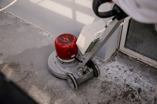 Betonschleifmaschine bei der Untergrundvorbereitung auf einem Balkon